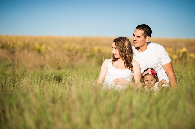 rodina v trávě na louce, muž, žena a holčička